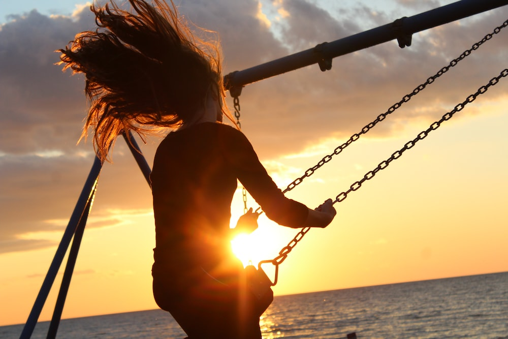 A silhouette of a person on a swing